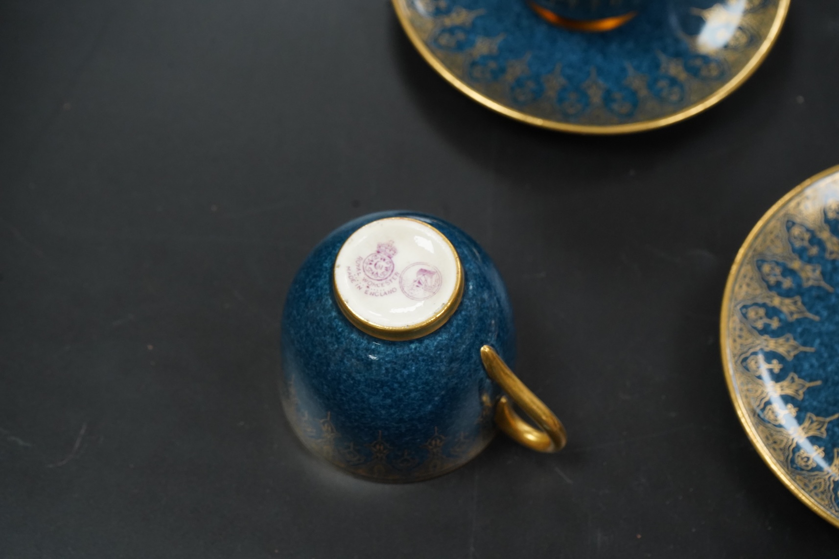 A set of six Royal Worcester cups and saucers, powder blue and gilt decoration, together with a set of six silver and enamel teaspoons